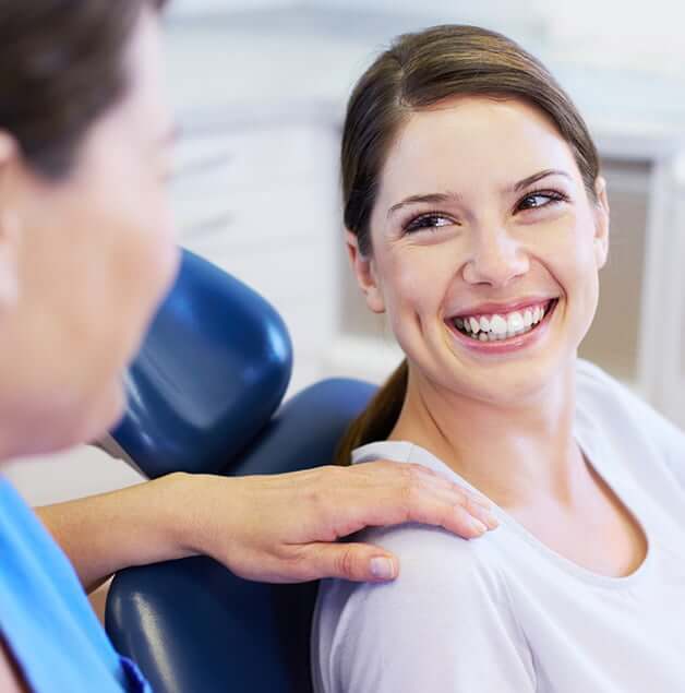 smiling woman talking with her dentist