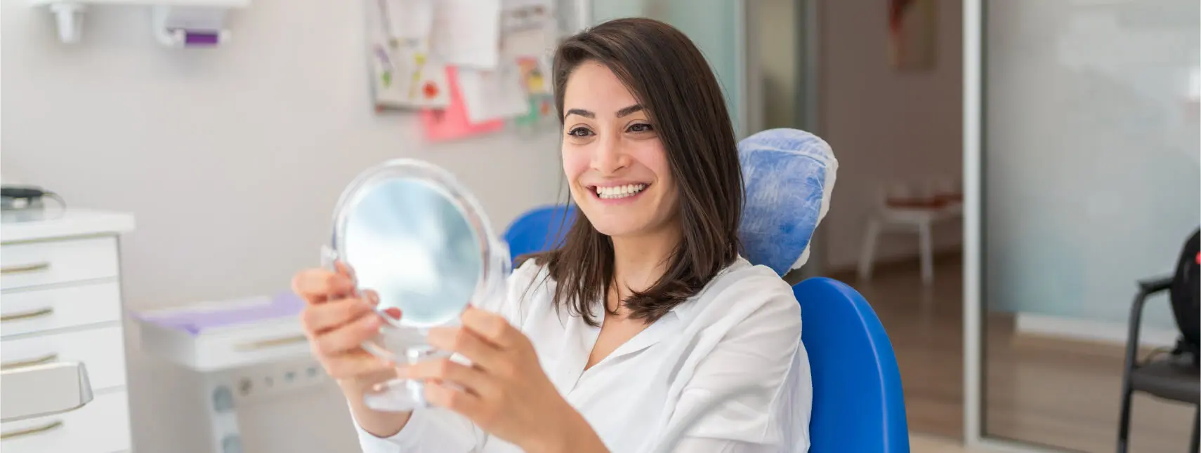 woman examining her smile in a mirror, dental veneers, johnson city, tn