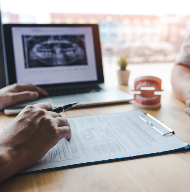 two people discussing dental-related paperwork