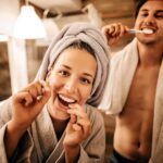 new years resolutions for your smile, couple brushing and flossing for a healthy sile