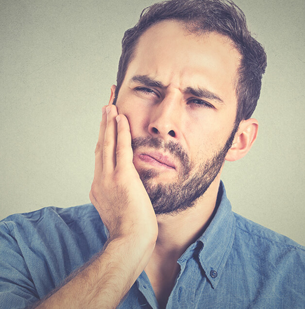 man holding his jaw in pain